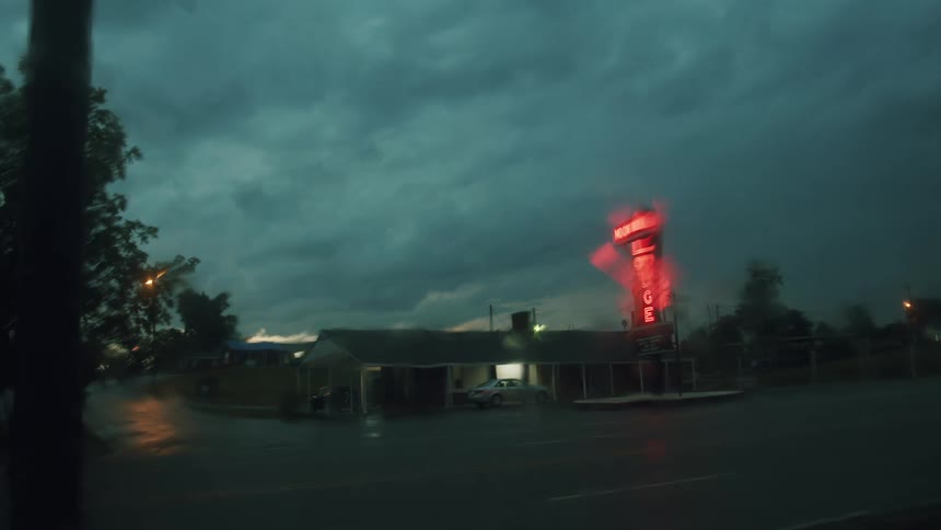 A car is parked outside of a building at dusk
