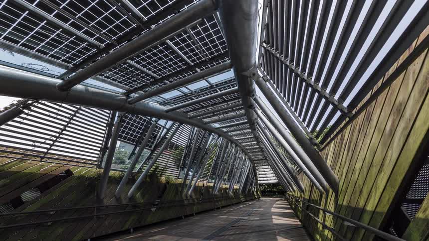 A metal pipe structure with a walkway in a city