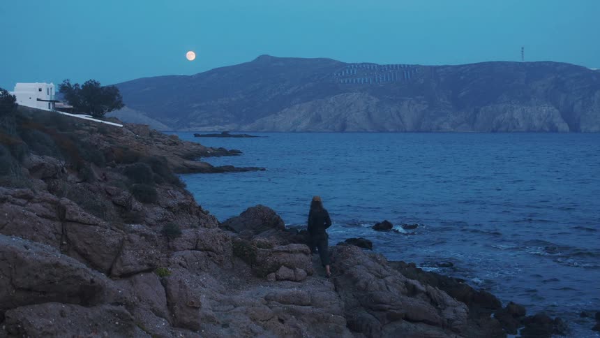 A woman hiking on the edge of the beach