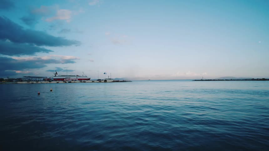 Ripples in the water with ships docked in the background