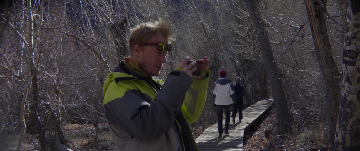 A man photographs the woods before joining the other hikers