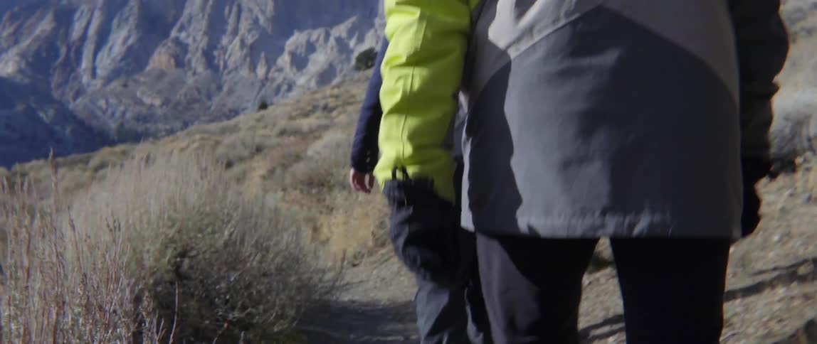 People Hiking Together Toward a High Mountain With Determination and Awe in the Distance.