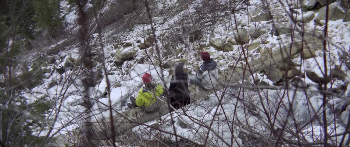 Three Friends Sitting on a Log on a Rocky Hill Sharing Laughter and Quiet Conversation.