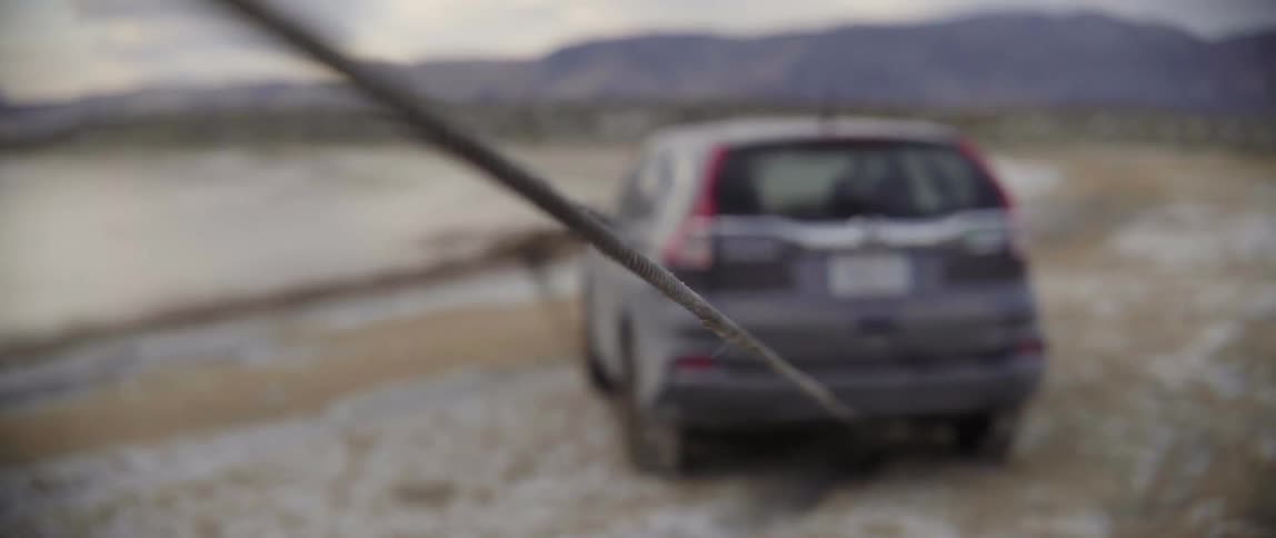 Winch cable pulling a stranded vehicle during a roadside assistance emergency mountain rescue.