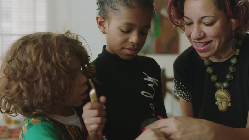 A mother and children cooking indoors