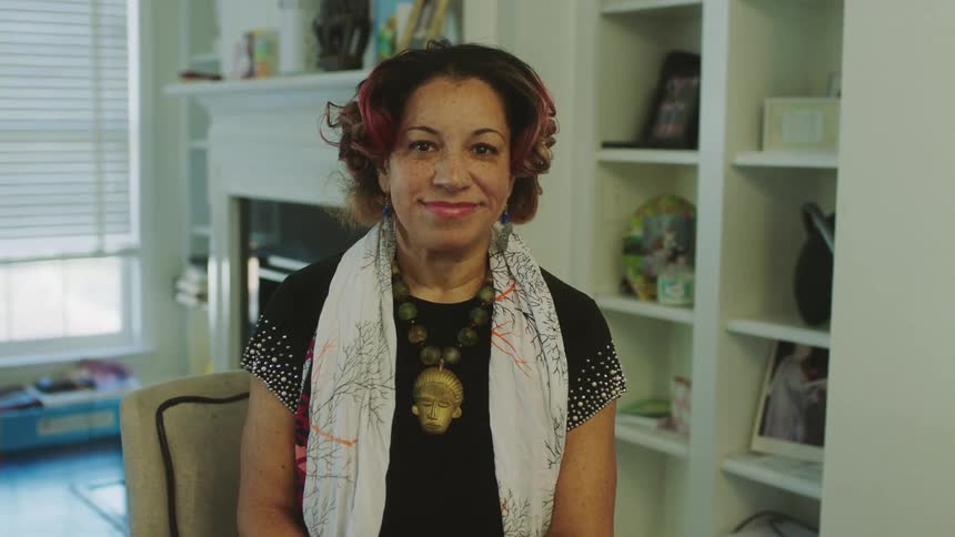 Woman sitting on a chair at home looking at the camera