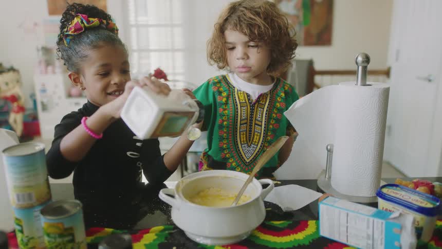 Two children are cooking in the kitchen
