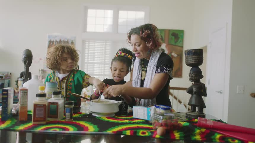A woman and children cook together at home
