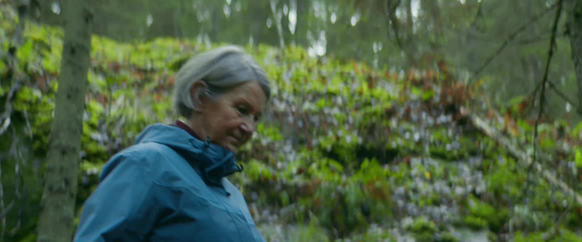 A woman stops to check her pulse while on a hike in the forest with friends