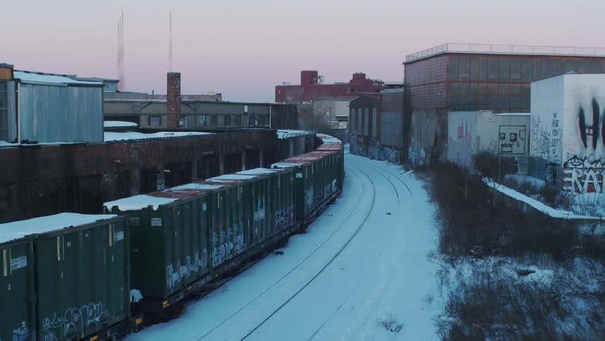 Snow covers train tracks at a shipping yard