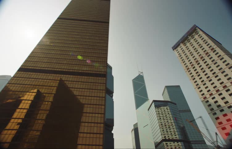 Footage of the facade of tall skyscrapers on the city skyline seen from a moving vehicle