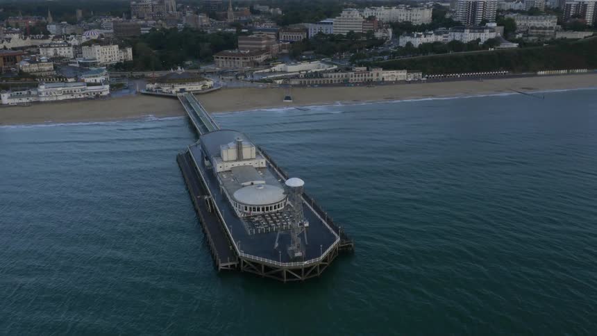 Aerial view of a commercial structure over a pier in the coast close to the city