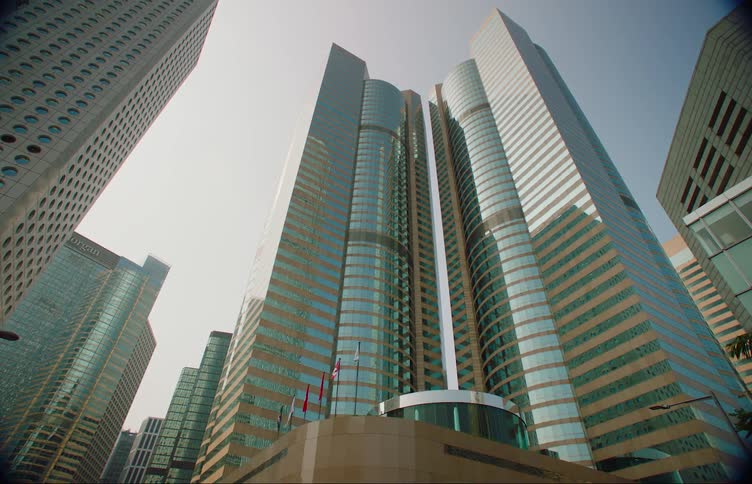 Flags in the wind outside a tall reflective skyscraper