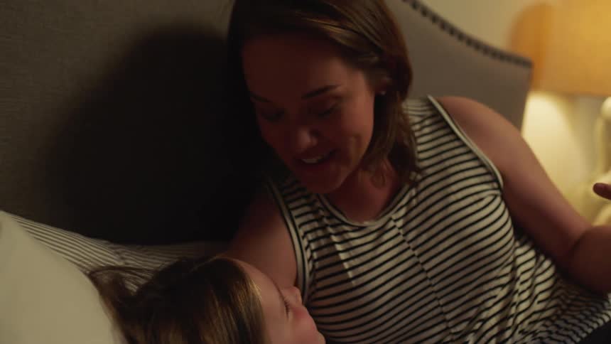 Mother telling her daughter a bedtime story in the bedroom at home