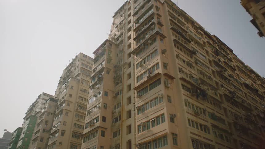 Large city buildings towering over a street in the daytime
