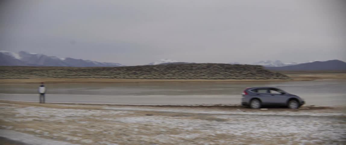Car stuck in the mud with a tow truck not far away
