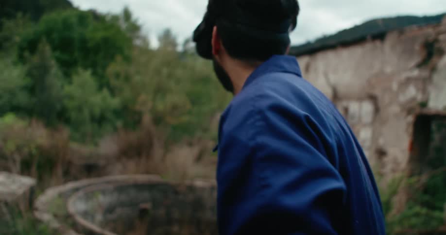 A young man plays a virtual reality game outside an abandoned building
