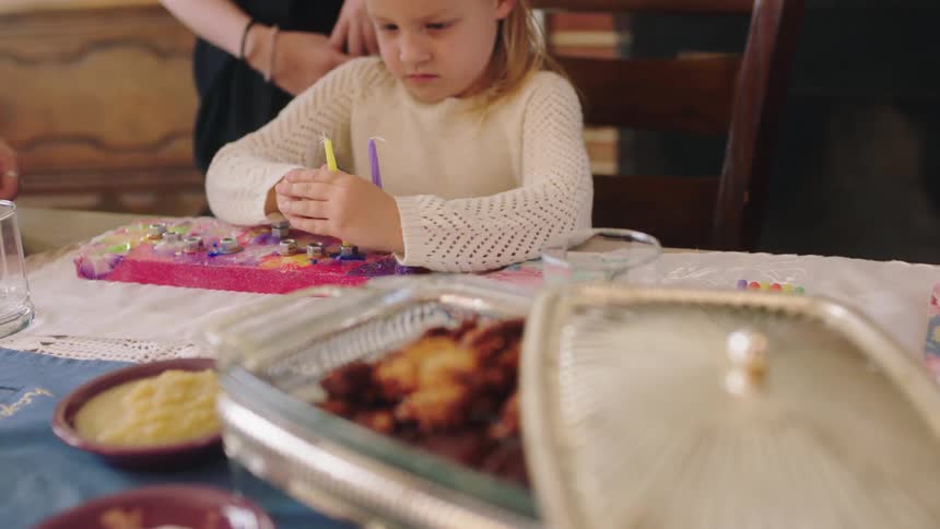 A daughter putting candles in a cake