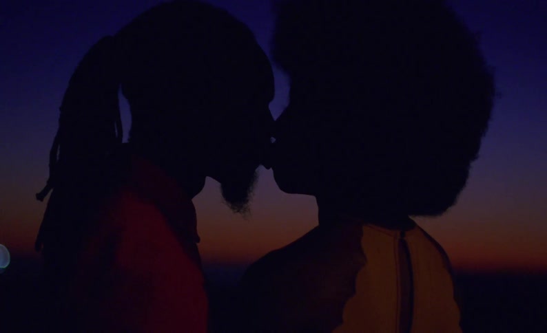 Silhouette of a couple tenderly kissing in the mouth outdoors at evening