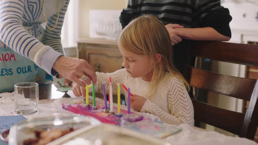 A mother and daughter are setting up candles on the table