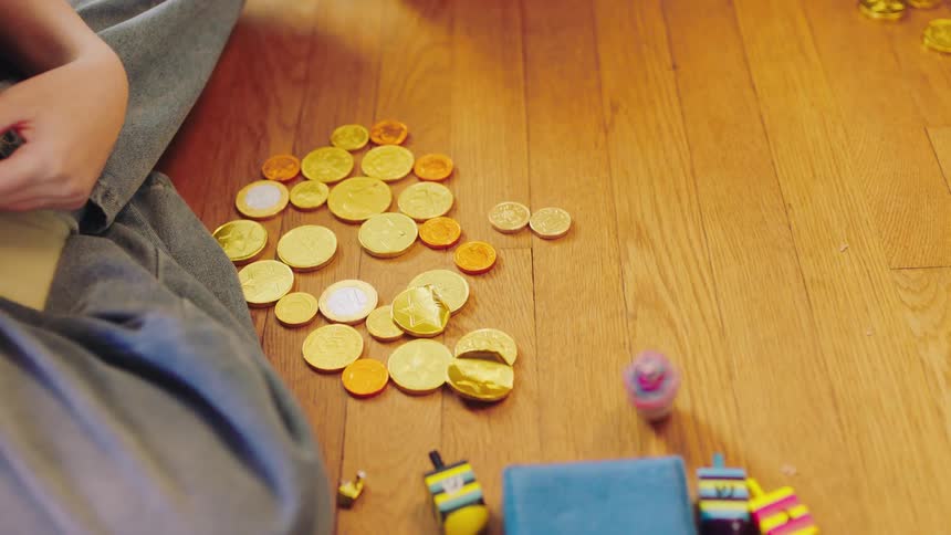 A woman sits on the floor with her children and plays a game