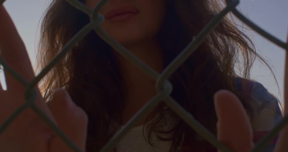 A woman moves her hands over the fence