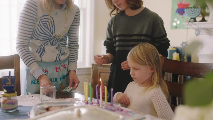 Mother tries to strike match then daughter lights candles with her match