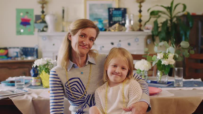 A mother and daughter sit and pose
