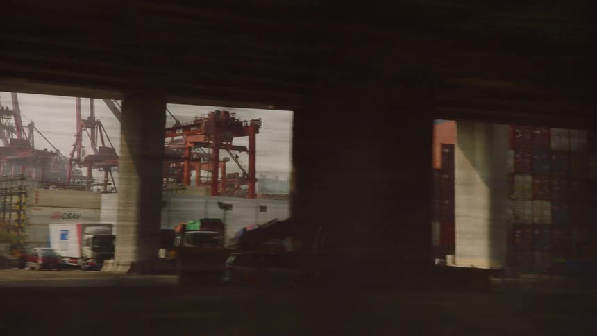 Shipping containers and vehicles outside a refinery