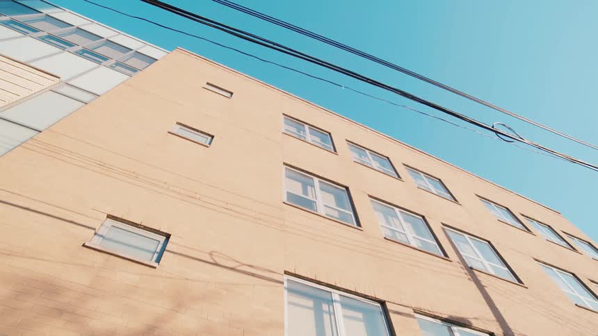 Static shot of the facade of a small office building under blue sky