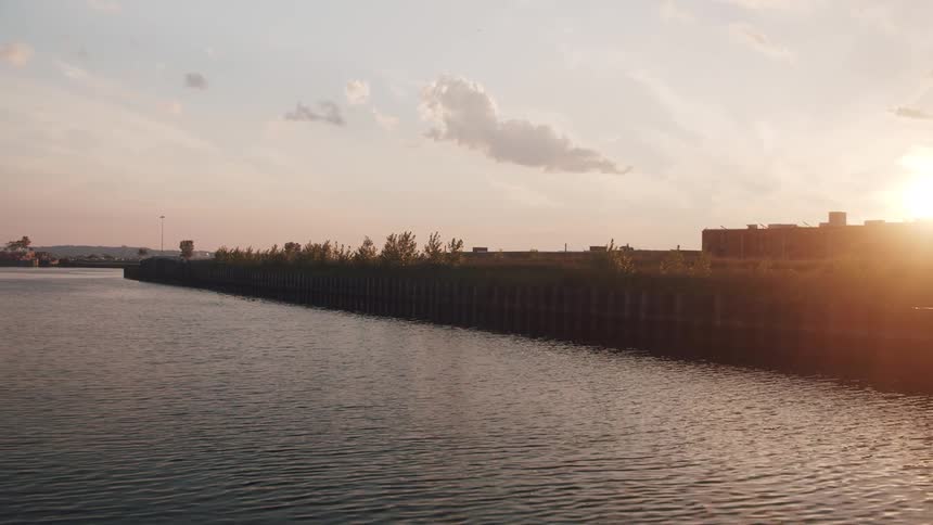 Calm sea water surface on close to a pier at sunset