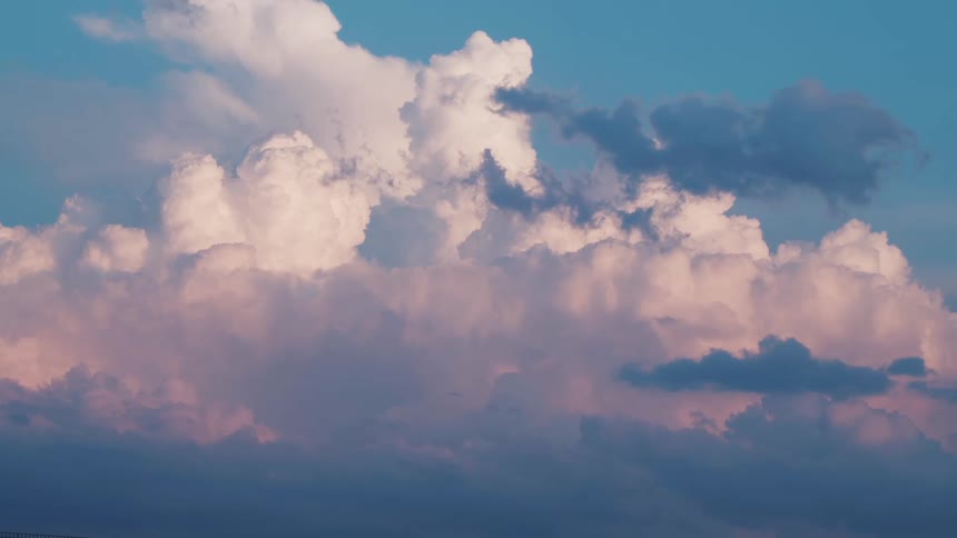 Sunlight reflects on cumulus clouds in a blue sky