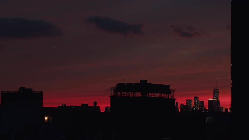 The sky is red as the sun sets on the city