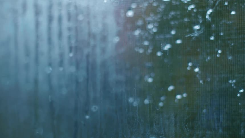 Window view of rain pouring on the trees