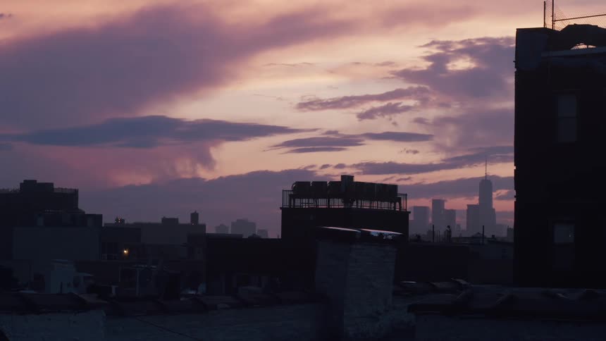 Silhouette of the skyline of the rooftops of buildings in the city at sunset