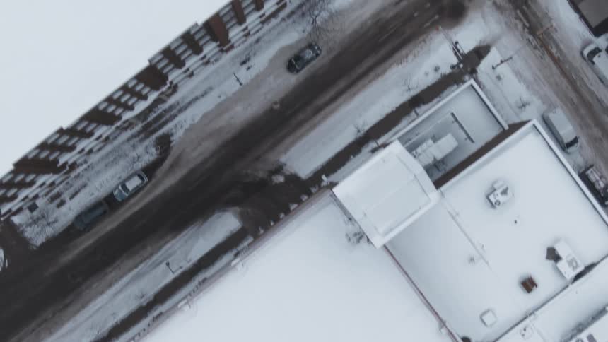 Aerial view of snowy rooftops and intersection in the city