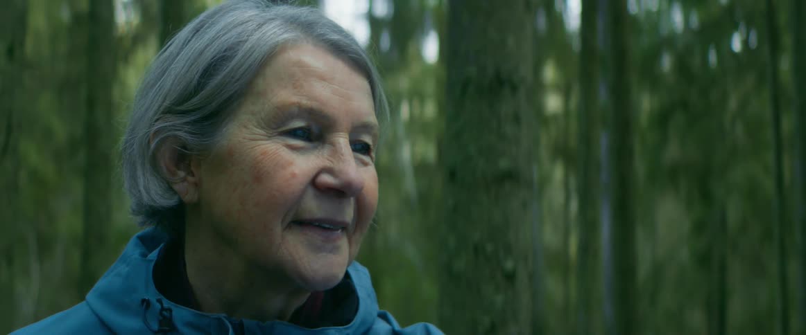 Close up of the face of an elderly woman standing on the forest
