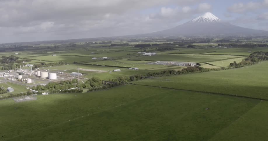 Aerial view of a large grass fields by a farm
