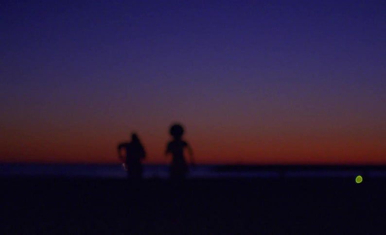 Silhouette of a young couple running towards the horizon at evening
