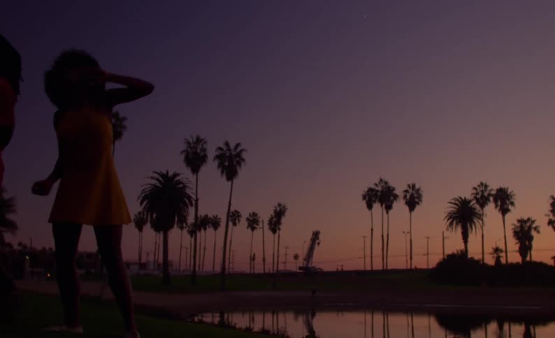 A man and woman dance on the shore