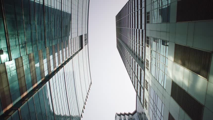 A view looking up between two tall skyscrapers high in the sky