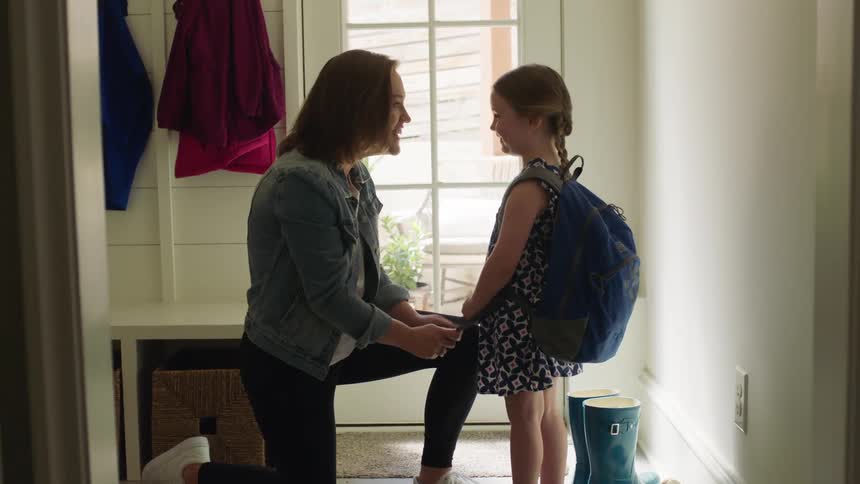 A woman talks to her daughter before school