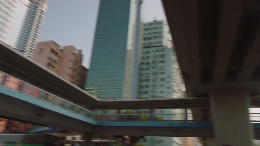 A downtown area with high rise office buildings and apartments and buses and cars driving as people walk down the sidewalk