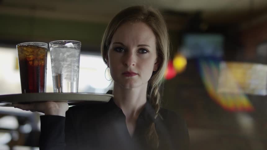 A woman is serving drinks at a restaurant