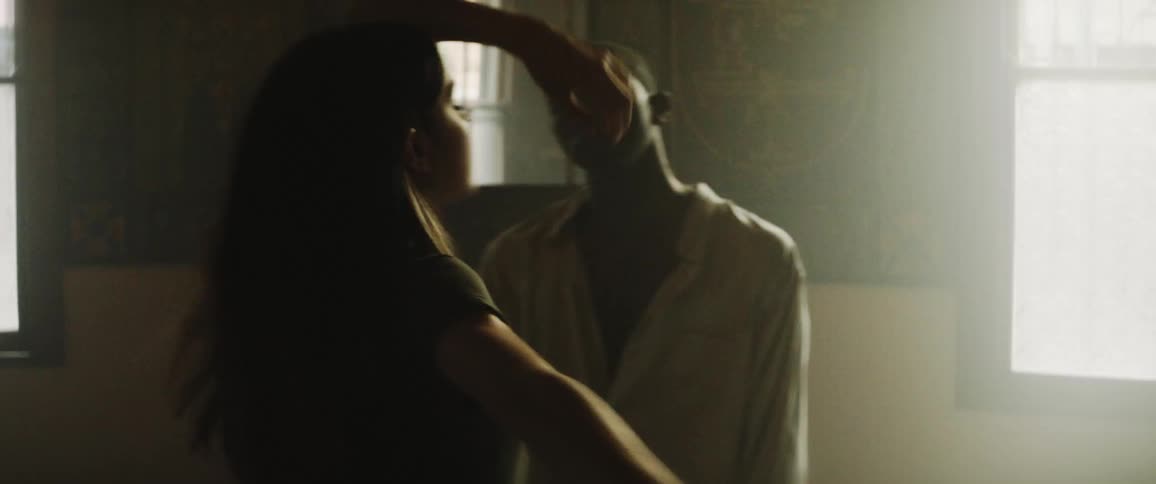 Man and woman dance in empty shadowy empty room