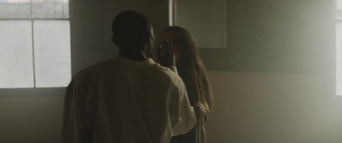 Male and female dancers move through dance in dimly lit room