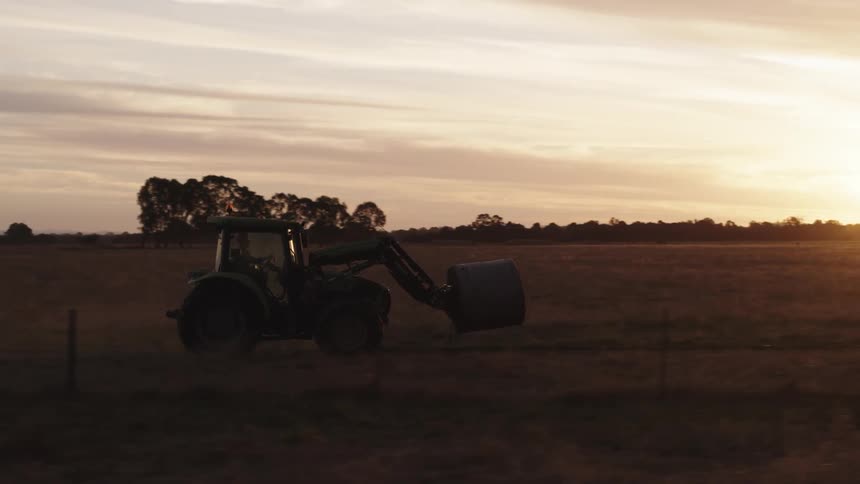 A man drives a tractor through a field