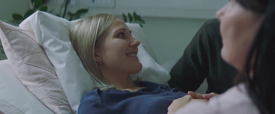 A woman lays in bed as she is being examined