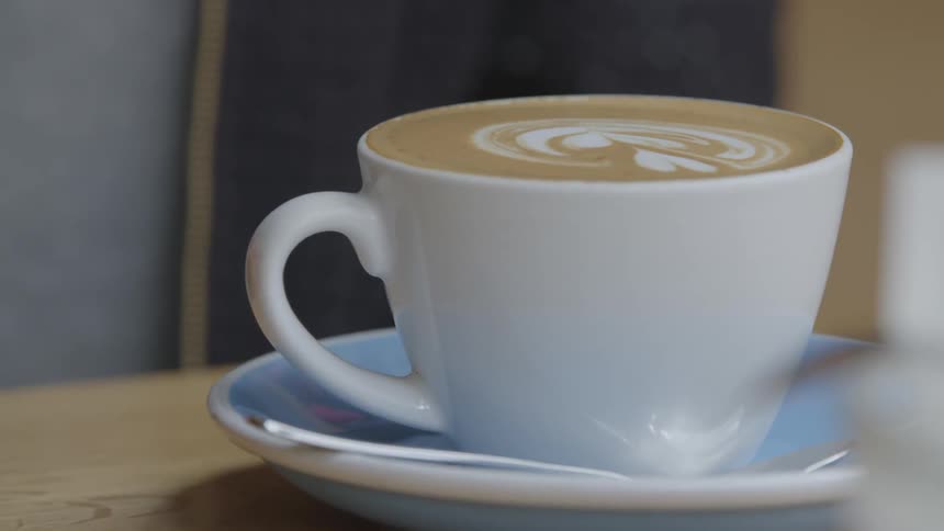 A h and reaches for a mug of coffee