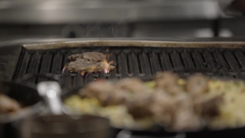 Steaks are being cooked on a grill